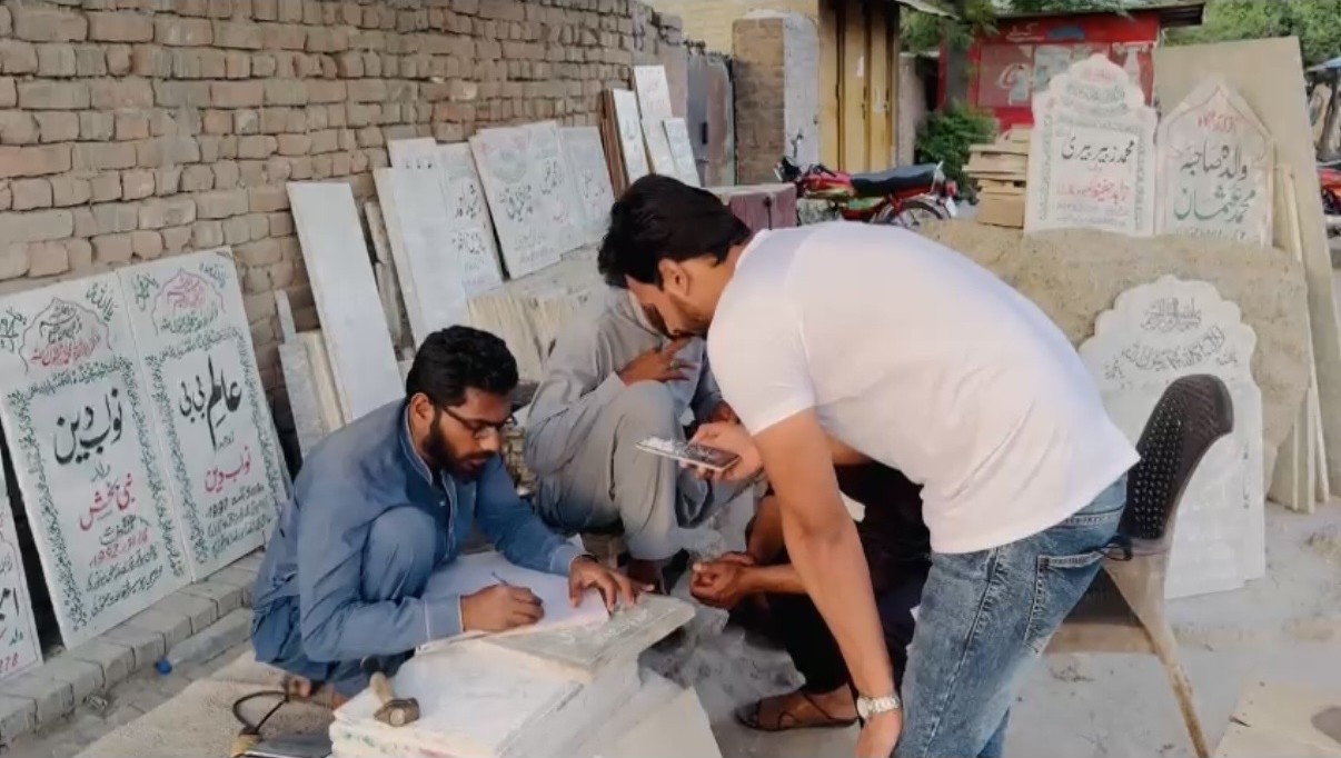 Local craftspeople preparing a commemorative marker for a community project