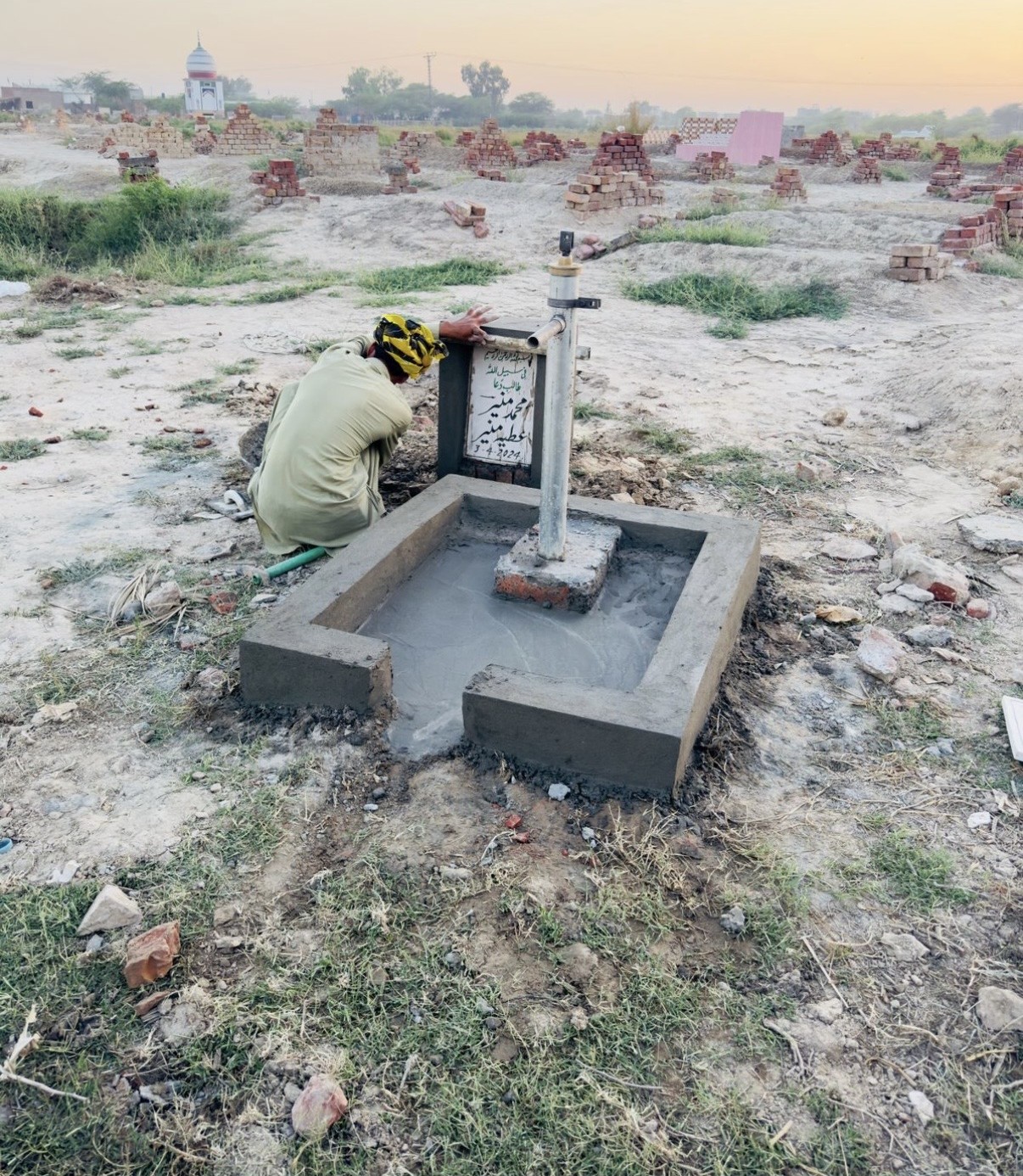 A local worker completing a hand-pump water well for the community