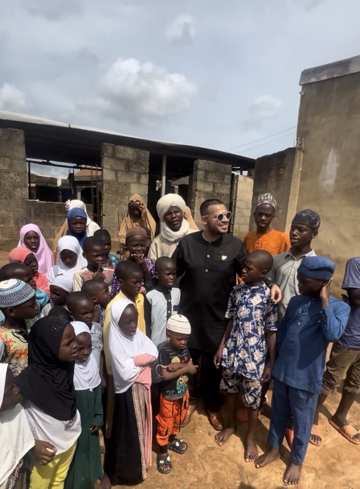 Zoaib Ali with children and community members during a local school visit in Africa