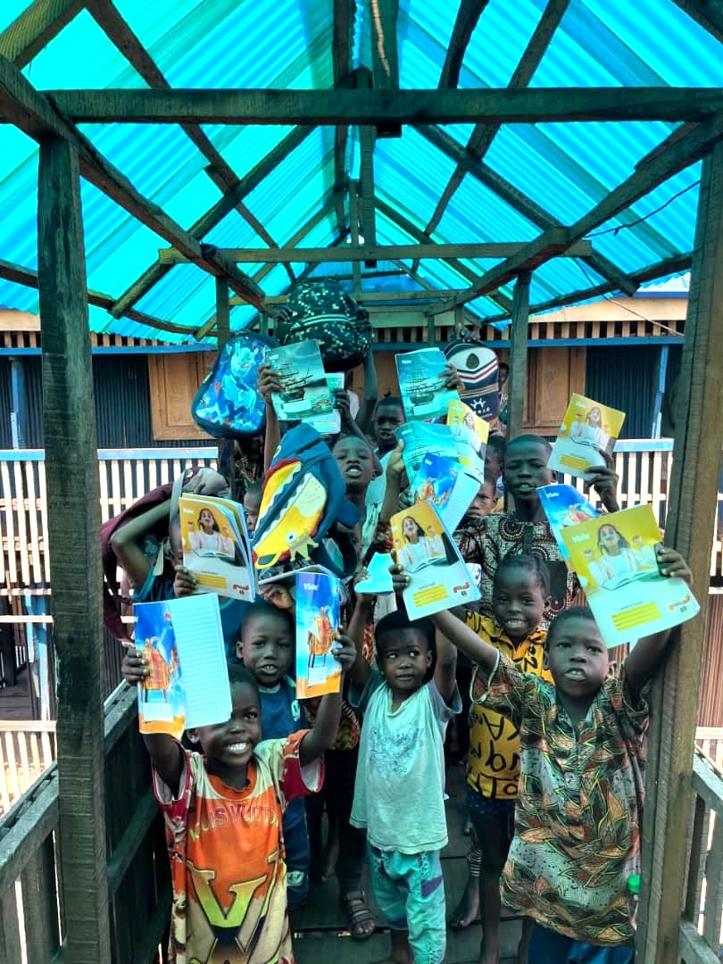Children holding books and learning materials during a school visit in Africa