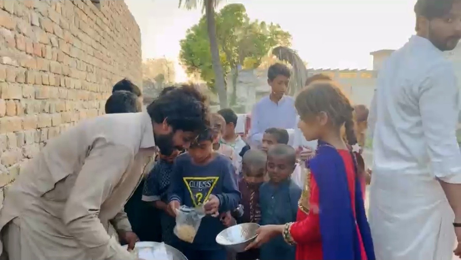 Children holding bowls as food is shared with them