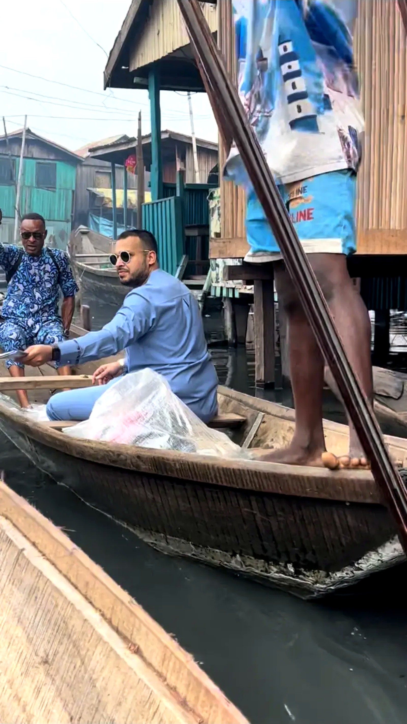 A canoe being paddled through the waterways of a stilt village