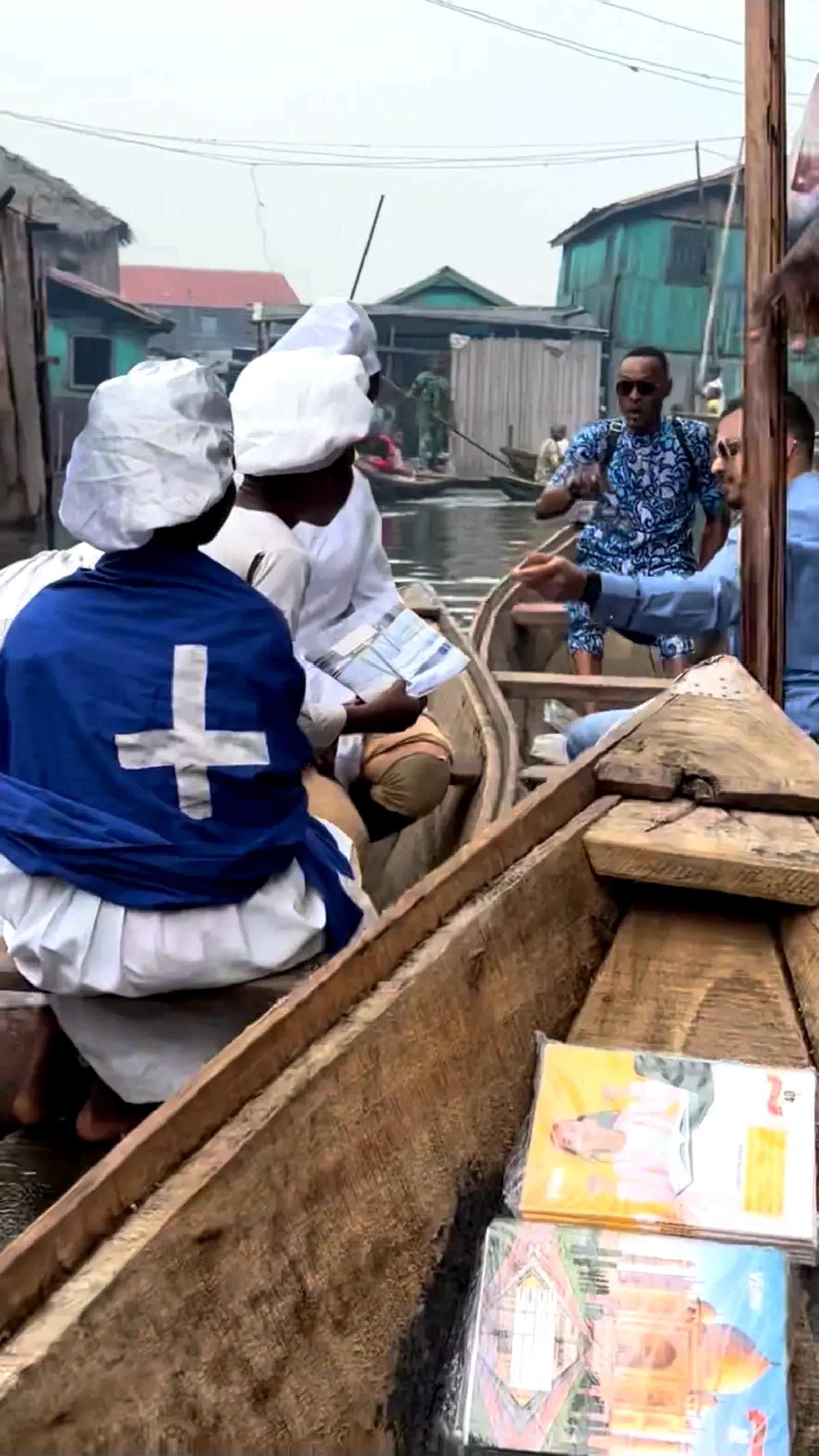 Learning materials being passed between canoes on the water