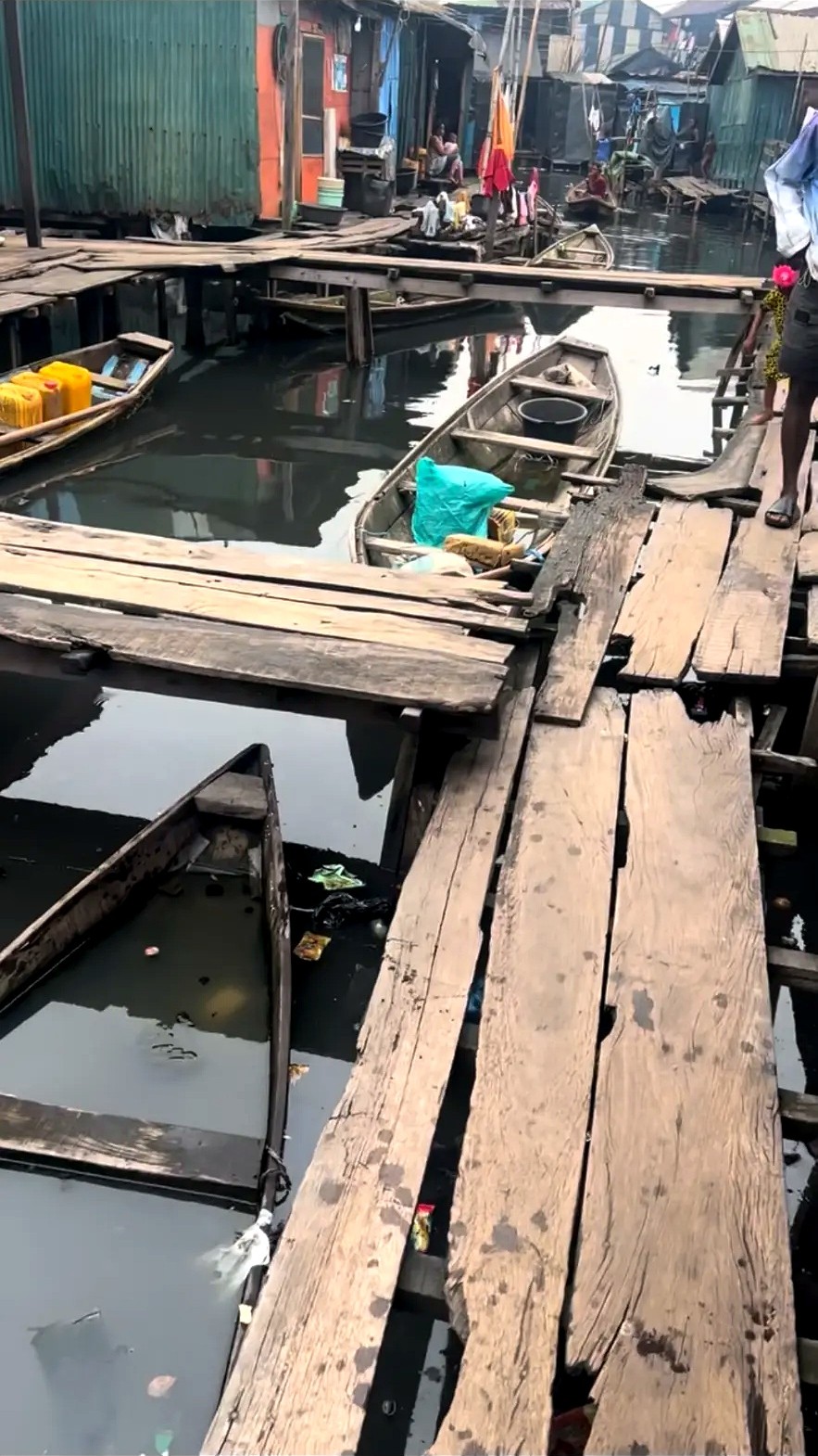 Wooden walkways and canoes between homes in a waterside community